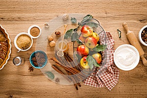 Ingredients for cooking Thanksgiving autumn apple pie with fresh fruits, cinnamon and walnuts on wooden table