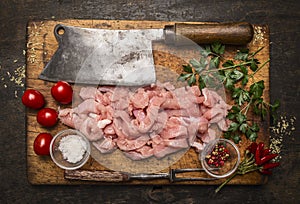 Ingredients for cooking a turkey,meat cleaver ,meat fork, salt ,pepper on a wooden cutting board on rustic wooden background top v