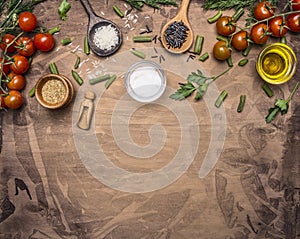 Ingredients for cooking vegetarian food cherry tomatoes, spices, herbs, oil, colorful rice in wooden spoons border ,place for tex