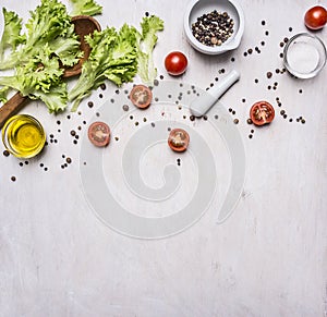 Ingredients for cooking Vegetarian Food, lettuce, cherry tomatoes, oil, salt and pepper wooden rustic background top view close