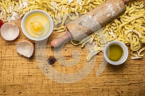 Ingredients for cooking vegetarian pasta tomatoes, butter, eggs, rolling pin on wooden rustic background top view close up bo