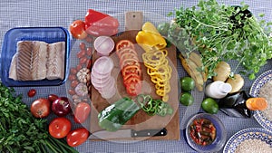 Ingredients distributed on a table covered with a blue checkered tablecloth.
