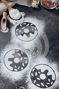 Ingredients for donuts baking. Spoon with flour, dishes, eggs, sugar on a grey background.