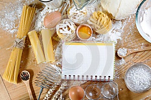 Ingredients for dough, cooking pasta tagliatelle spaghetti, including flour, eggs, milk, on wooden rustic background, empty space