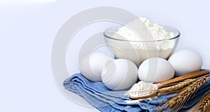 Ingredients for dough. Flour  eggs and ears of wheat on the white background. Close-up. Copy space