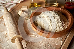 Ingredients for dough on pastry board with flour and rolling pin on  table
