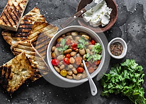 Ingredients for  goats cheese crostini with garlicky beans on a dark background, top view