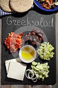 Ingredients for Greek salad on a slate cutting board