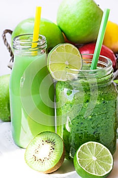 Ingredients for green fruit juice, glass jar mug with vegetable smoothie on wood table, outdoors