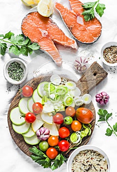 Ingredients for healthy, balanced lunch - salmon and vegetables. Red fish, zucchini, squash, cherry tomatoes, leek, wild rice, sp