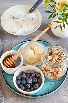 Ingredients for a healthy breakfast: yogurt, muesli, fruits and honey