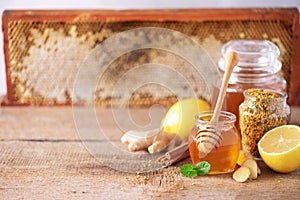 Ingredients for healthy hot drink. Lemon, ginger, mint, honey, apple and spices on wooden background. Copy space. Alternative