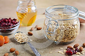 Ingredients for homemade oatmeal granola. Oat flakes, honey, almond nuts, dried cranberries and apricots. Healthy breakfast concep