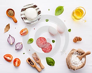 The ingredients for homemade pizza on wooden background.