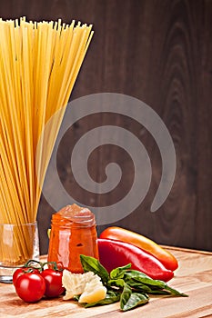 Ingredients for italian pasta on wooden background.