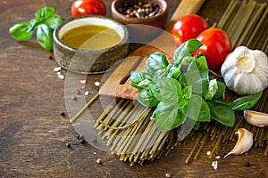Ingredients for italy cuisine. Spinach spaghetti, herbs, spices, olive oil and tomatoes.