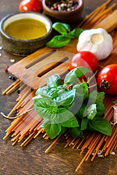 Ingredients for italy cuisine. Tomato spaghetti, herbs spices, olive oil and vegetables.