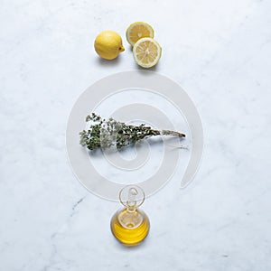 Ingredients from Italy, Isolated on Marble Background Ã¢â¬â Cut Slices of Lemon, Extra Virgin Olive Oil in Cruet, Bundled Oregano photo
