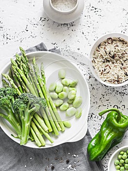 Ingredients for lunch - wild rice, asparagus, broccoli, green beans on a light background, top view. Vegetarian food
