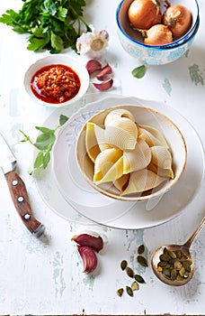 Ingredients for making conchiglie pasta with spicy red pesto