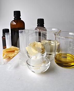 Ingredients for making natural cosmetics cacao butter, coconut, almond, jojoba and essential oils with tubes and bottles