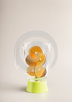 Ingredients for making orange juice, sliced oranges in a green glass blender, space for text