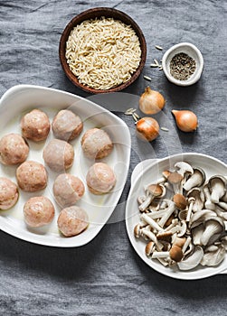 Ingredients for making orzo mushrooms pasta with teriyaki sauce chicken baked meatballs on a gray background, top view