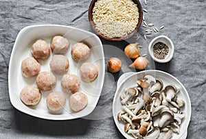 Ingredients for making orzo mushrooms pasta with teriyaki sauce chicken baked meatballs on a gray background, top view