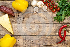 ingredients for making pizza on a wooden table with space for text, top view