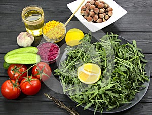 Ingredients for making salad, cucumbers, tomatoes and arugula on a plate.