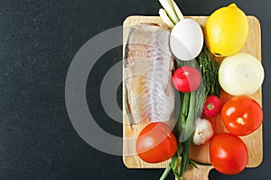 Ingredients for natural food from ripe tomatoes, onion, garlic, lemon, radish, eggs and fish meat. Organic foodstuffs. Top view on