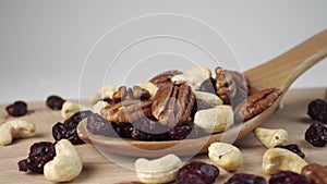 Ingredients of a nutty fruit mixture in a wooden spoon on a board