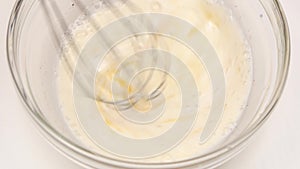 Ingredients for omelette mix with whisk in glass plate, closeup