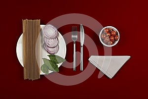 Ingredients for pasta recipe with white plate napkin & knife & fork