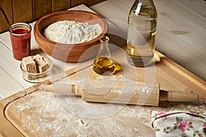 Ingredients for pizza dough flour with olive oil and yeast on wooden  table