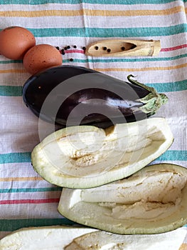 Ingredients for preparing healthy food 2 eggs,eggplants pepper,blue eggplant, preparing stuffed blue eggplant on striped canvas