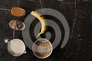 Ingredients for a Protein-Rich Smoothie: Fresh Banana, Rolled Oats, Creamy Milk, and Chocolate Protein Powder