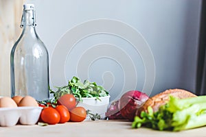 Ingredients for salad, fresh vegetables, olive oil on the table in the kitchen. culinary and food concept