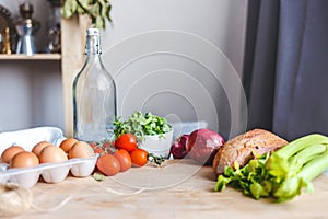 Ingredients for salad, fresh vegetables, olive oil on the table in the kitchen. culinary and food concept