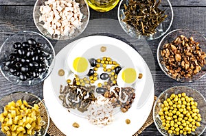 Ingredients for salad in transparent plates on a black wooden background. Fried champignons, olives, pickled cucumbers, chicken fi