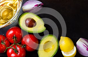 Ingredients for sauce guacamole on black stone background