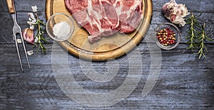 Ingredients and seasonings for the roast pork on a board with a fork, on a wooden background, Border