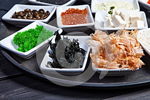 Ingredients for sushi on black plate in dark wooden background