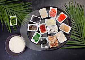 Ingredients for sushi on black plate in dark wooden background