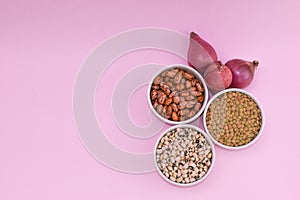 ingredients to make a vegan and vegetarian meal.  Lentils and beans for healthy food.  organic legumes on pink background, onion photo