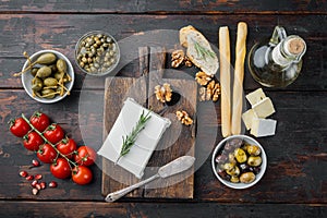 Ingredients for traditional greek salad, on dark wooden background, flat lay