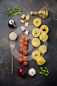 Ingredients for traditional Italian pasta dish. Uncooked raw tagliatelle bolognesi, parmesan cheese, olive oil, garlic, basil