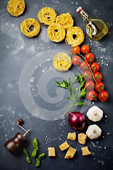 Ingredients for traditional Italian pasta dish. Uncooked raw tagliatelle bolognesi, parmesan cheese, olive oil, garlic, basil