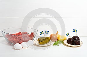 Ingredients for a traditional Swedish dish beef Lindstrom. Freshly minced beef, boiled potato, white chopped onion, pickles, pickl