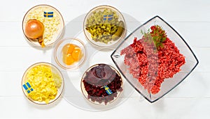 Ingredients for a traditional Swedish dish beef Lindstrom. Freshly minced beef, boiled potato, white chopped onion, pickles, pickl